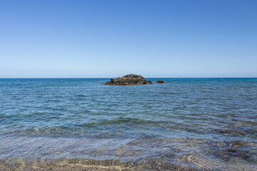 Small volcanic island rock in the middle of calm turquoise ocean water on the Big Island Hawaii © Joao Vieira