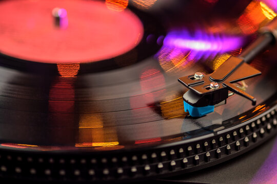 Vintage vinyl record player with spinning turntable in warm bokeh lighting