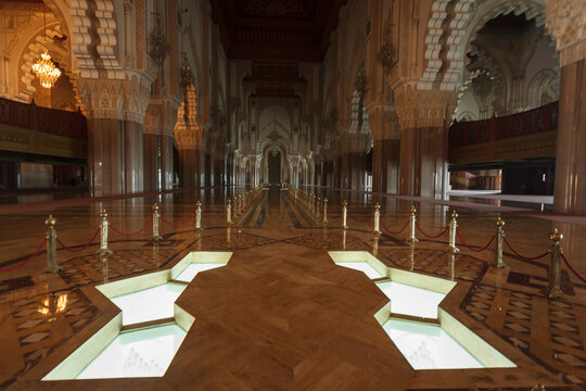 Illuminated grand corridor and pools in the interior of the historic mosque in Casablanca, Morocco