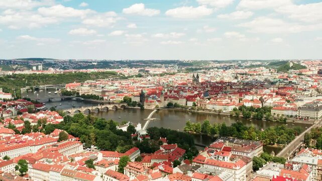 Historic landmark Charles Bridge crosses Vltava river in central Prague. European architecture showcases iconic red roofs. Scenic cityscape represents travel and tourist attraction.