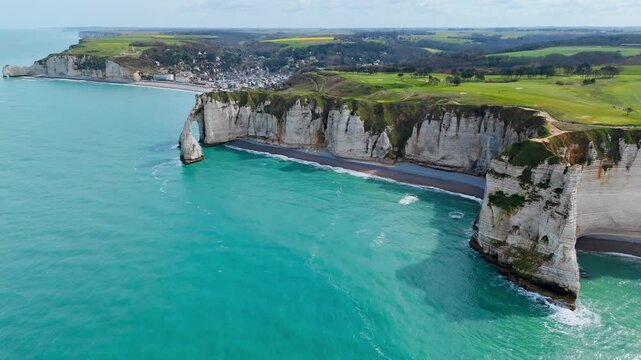 Normandy chalk cliff formations with visible limestone layers above sea. Drone footage focused on coastal geology and erosion