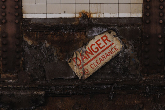 Decayed danger warning sign on grungy wall