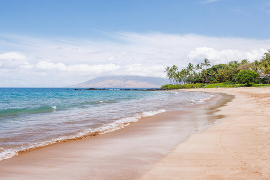 Sunny beach in Hawaii with golden sand, clear water under a bright sky