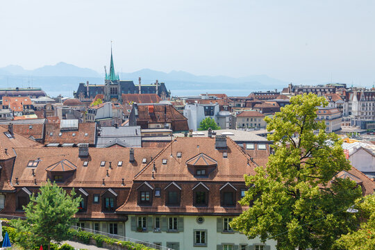 Rooftops of a Swiss city on a bright sunny day with a lake