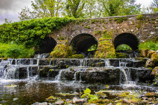 Killukin Cascade Waterfall and historic stone bridge in County Roscommon Ireland with cascading water, moss-covered rocks and lush riverside scenery
