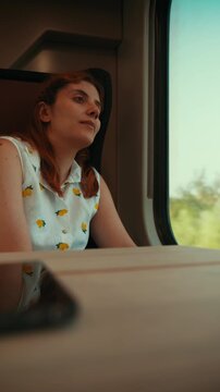 Nostalgic young woman returning to work after summer vacation train journey