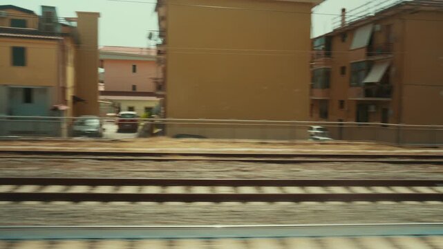 A train journey through an Italian city, viewed from the window houses passing