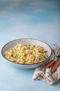 Tabbouleh salad couscous vegetables bowl Middle Eastern blue background