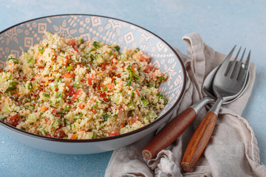 Tabbouleh salad couscous vegetables bowl Middle Eastern blue background