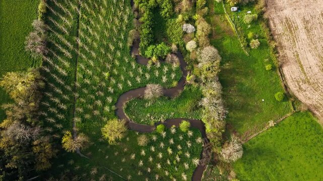 Meandering river through green Normandy countryside, aerial view. Natural river curve creates strong aerial landscape pattern