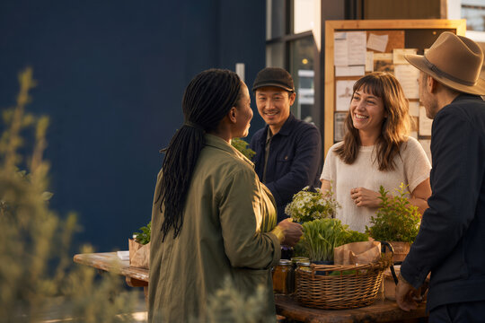 Hyper-local community market conversation around wooden table with local produce handmade goods and bulletin board highlighting analog lifestyle neighborhood civic life human connection