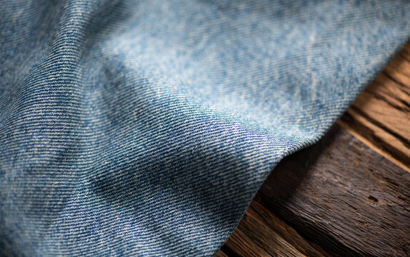 Blue denim cotton jeans fabric texture border design, jean on wooden background, textile backdrop, top view. wallpaper, washed effect jean fabric close up, flat lay