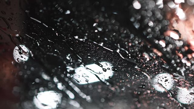 雨に濡れたガラス表面を伝う水滴のクローズアップ