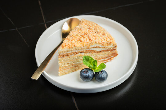 Medovik. Honey cake made from honey cakes with whipped sour cream, decorated with berries, pomegranate and flowers