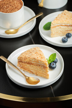 Medovik. Honey cake made from honey cakes with whipped sour cream, decorated with berries, pomegranate and flowers