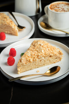 Sliced Napoleon cake on a white wooden table. Classic dessert