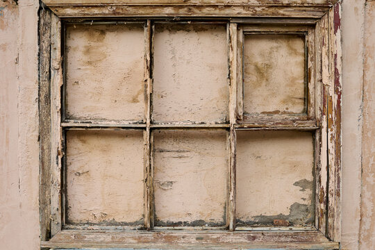 Old weathered wooden window frame without glass with high resolution. Beige background. Copy space.