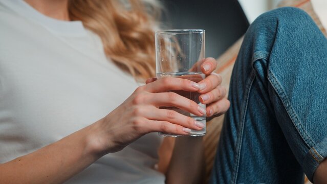 Closeup unrecognizable Caucasian woman holding glass drinking water cropped view unknown female drink hold beverage relaxing at home lady with healthy nutrition diet detox vitamins health care concept