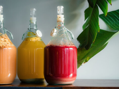 Different hydromel liquids are fermenting on wooden counter at home 