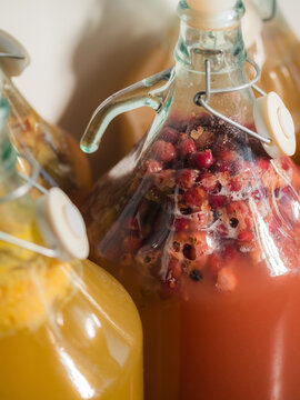 Colorful Bottles of Homemade Drinks on a Table in a Kitchen