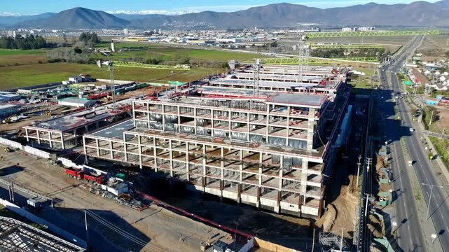 Aerial view of hospital construction site with surrounding vineyards and road Keywords extra: vineyards, agricultural land, road, vehicles, establishing shot