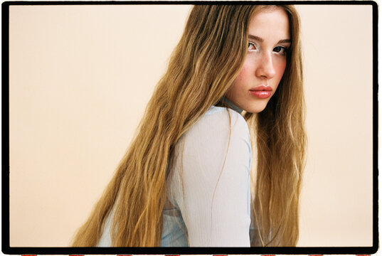 Woman with long blonde hair looking back