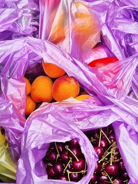 Fruits in colorful plastic bags at a market