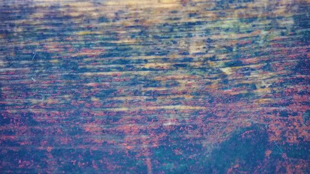 Drippings, drip. The falling drops break on a board made of old wood and form water craters and splashes.