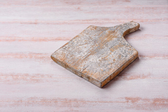 A square wooden cutting board for home food preparation. A wooden cutting board