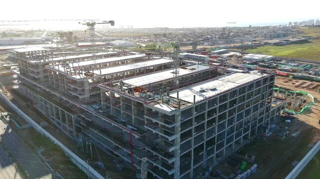 High angle aerial view of hospital building structure with tower crane Keywords extra: tower crane, rooftop, top view, machinery, overhead shot, green field