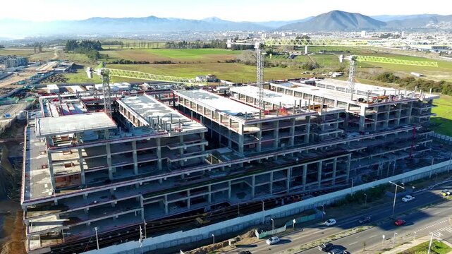 Wide aerial view of hospital construction site surrounded by open farmland Keywords extra: farmland, open field, rural, landscape, wide shot, panoramic