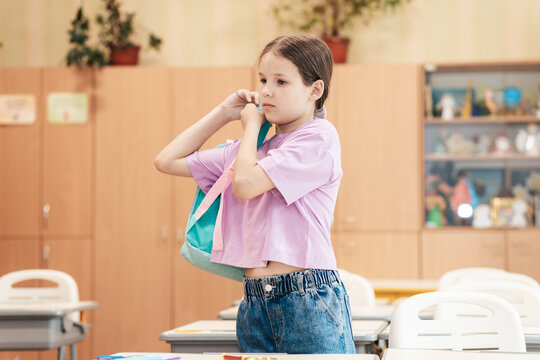 Young Girl Prepares to Leave Classroom, Carrying Colorful Bag After an Engaging Day of Learning and Exploration in a Vibrant Educational Setting