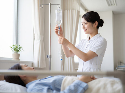 病室で点滴の滴下チューブを手際よく調整する笑顔の看護師