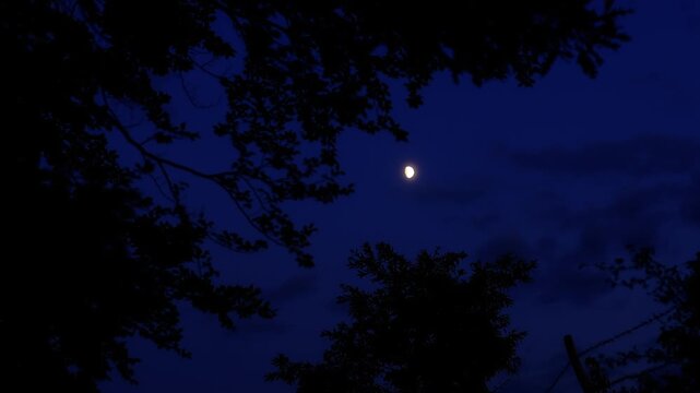 Moon on a twilight sky with landscape mountain silhouettes.