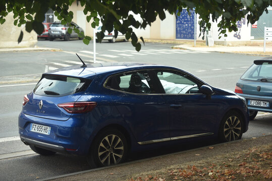 St - Amand Montrond - France - 3 august 2026 - Three quarter rear view of a dark blue Renault Clio V parked on a street, showing a modern French compact hatchback in an urban environment.
