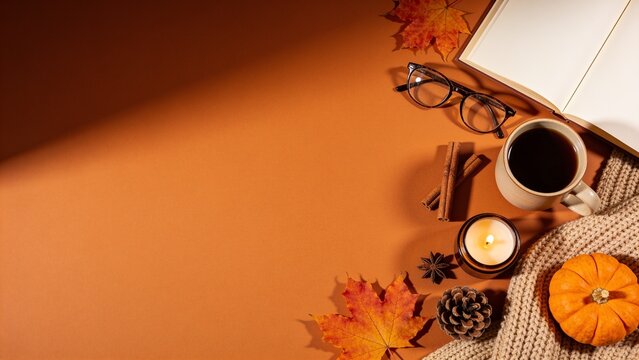 Cozy autumn desk setup with warm drinks and fall leaves on wooden tray