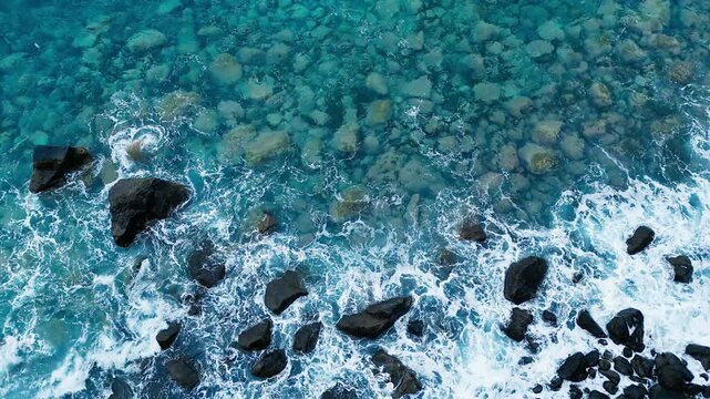 Atlantic ocean waves washing rocks in clear turquoise water, coastal texture with sea foam patterns