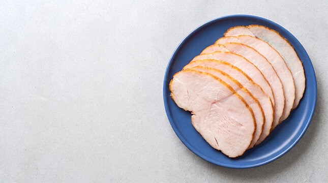 Sliced smoked turkey breast on a blue plate with copy space