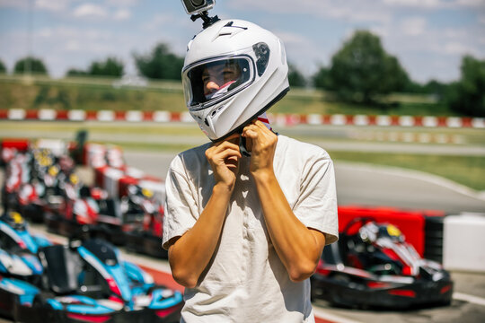 Post-race portrait of a teenager removing his helmet by the track
