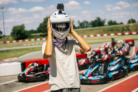 Driver taking off his helmet after a fast go-kart race outdoors