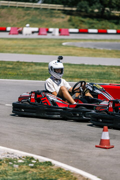 Teenage boy drifting around a curve in a go-kart on a racing track