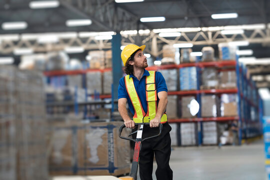 Male warehouse worker manage inventory, process incoming and outgoing stock, organizes, and moves stock inside a storage or fulfillment center