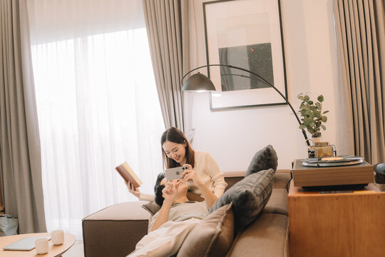 Happy Asian couple enjoying time together in their new home