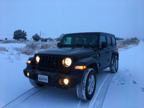 Kayenta, United States; December 28 2019: Off road vehicle driving on snowy US 160 in Arizona