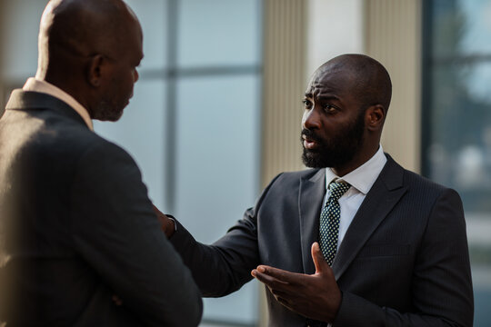 Two businessmen having serious discussion at office building