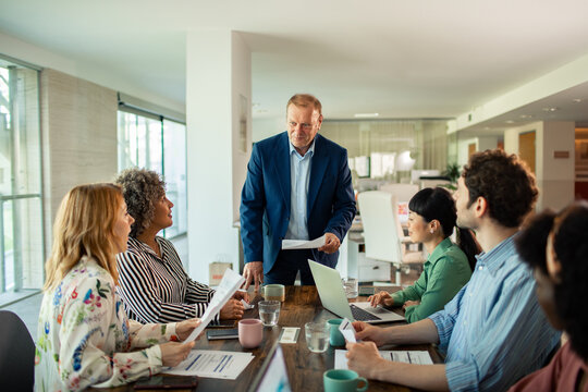 Senior manager leading team meeting in modern office