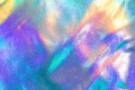 Iridescent holographic texture background with rainbow metallic sheen and abstract colorful light reflections