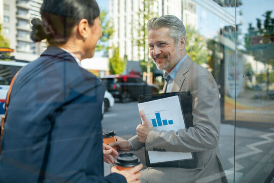 Business colleagues discussing data on a city street