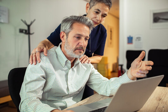 Senior couple discussing finances at home office