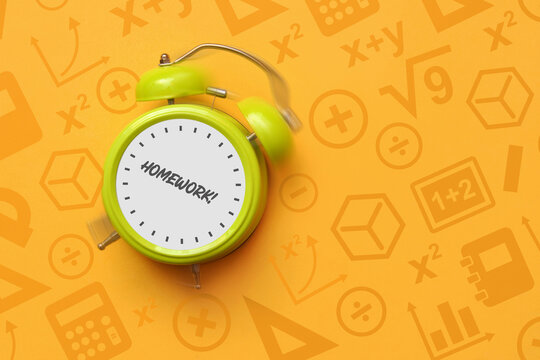 Green alarm clock with Homework text on educational background, back to school concept